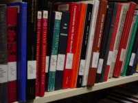 Books on a shelf with call numbers showing - photo